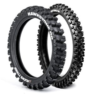 Two black off-road dirt bike tires with visible Plews branding on a white background