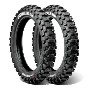 Two Plews off-road dirt bike tires with knobby tread pattern on a white background